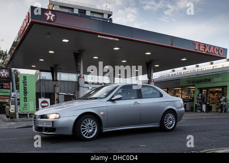 Une voiture quitte un remplissage sur la staion de Texaco Caledonian Road à Islington, au nord de Londres, un dimanche matin de novembre. Banque D'Images