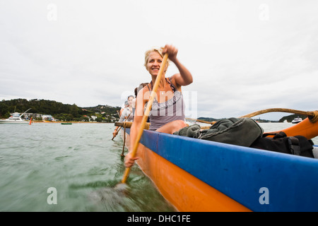 Pagayer sur un Waka dans la Bay of Islands, Nouvelle-Zélande Banque D'Images