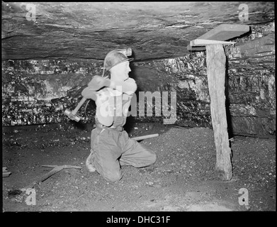 Harry Fain, un chargeur de charbon à Inland Steel Company, est vu en train de sécuriser le bois près de la mine avant de commencer son travail. Le bois contribue à assurer la sécurité des travailleurs dans la mine en empêchant les effondrements. Les opérations d'extraction de charbon comme celles-ci ont été critiques pendant l'ère industrielle. Banque D'Images