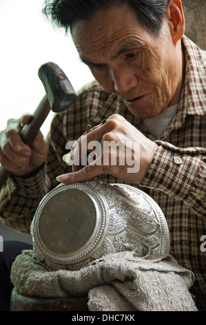 Portrait d'un vertical silver smith talent un bol en argent gravure au Laos. Banque D'Images