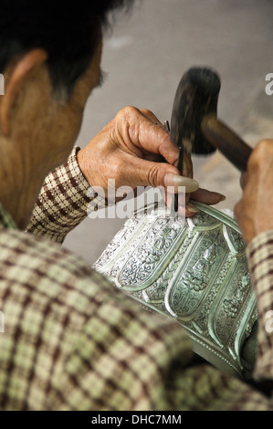 Portrait d'un vertical silver smith talent un bol en argent gravure au Laos. Banque D'Images