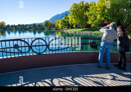 Couple profitant de la vue depuis un pont sur le lac, le Cheyenne, Broadmoor hôtel historique de luxe et resort, Colorado Springs, CO Banque D'Images