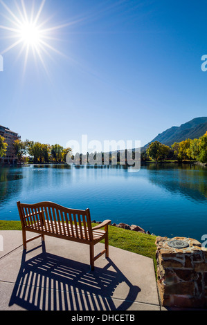 Banc en bois patiné surplombe le lac, Cheyenne, Broadmoor hôtel historique de luxe et resort, Colorado Springs, Colorado, États-Unis Banque D'Images