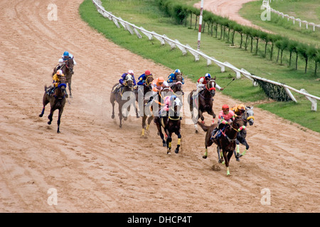 Jockeys de chevaux Throughbred sont équitation chevaux sur un champ de courses de chevaux à un à Khorat, Thaïlande. Banque D'Images