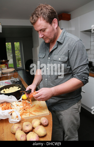 Un homme l'épluchage des carottes. Banque D'Images