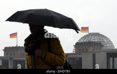 Berlin, Allemagne. 07Th Nov, 2013. Un homme est titulaire d'un parapluie sous la pluie devant le bâtiment du Reichstag à Berlin, Allemagne, 07 novembre 2013. Photo : WOLFGANG KUMM/dpa/Alamy Live News Banque D'Images