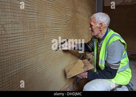 Plâtrier traditionnel à l'aide de chaux traditionnel Ben Graham et de mortier sur un mur Banque D'Images