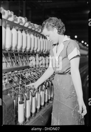À l'usine de fils de Pickett à High point, en Caroline du Nord, un travailleur hautement qualifié exploite un speeder et un peigneur pour monter les extrémités de fils dans l'industrie textile. Banque D'Images