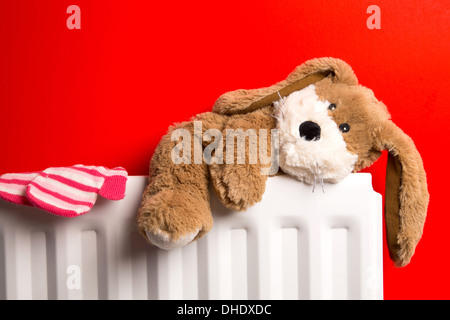 La chambre de l'enfant avec un ours en peluche et une paire de mitaines placé sur le dessus d'un radiateur de chauffage. Banque D'Images