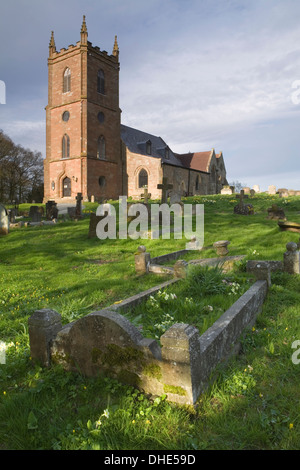 L'église St Mary Vierge Hanbury. Le faible soleil au coucher du soleil jette de longues ombres sur les tombes dans le cimetière. Banque D'Images