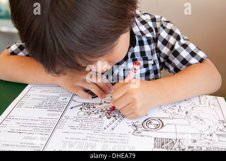 Libre d'un jeune garçon en coloriant un menu diner enfants Banque D'Images