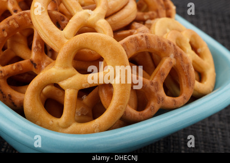 Un tas de Bretzels salés dans une assiette bleue Banque D'Images