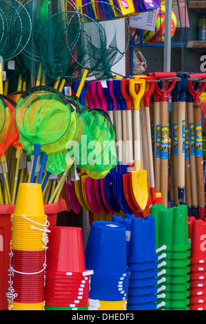 Des seaux et des pelles traditionnelles en vente dans une boutique de bord de mer à Lyme Regis, dans le Dorset, Angleterre, Royaume-Uni, Europe Banque D'Images