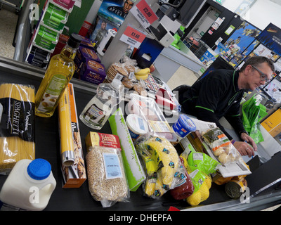 Un employé travaillant à la caisse remplie de nourriture La nourriture dans un supermarché COOP de Galles UK KATHY DEWITT Banque D'Images