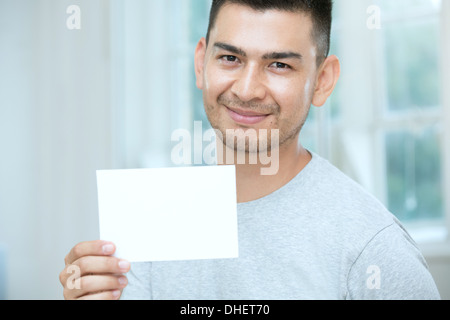 Mid adult man holding a blank card Banque D'Images