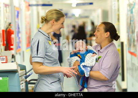 Une infirmière pédiatrique et travailleur de soins de s'occuper d'un bébé UK Banque D'Images