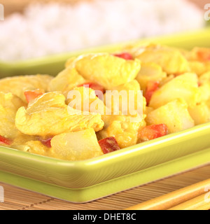 Poulet-curry de mangue avec poivron rouge et pommes de terre, riz cuit dans le dos Banque D'Images