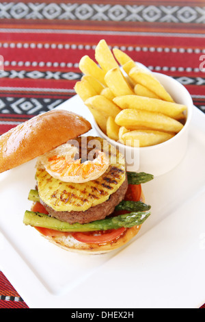 Burger de bœuf et de fruits de mer à l'ananas, asperges, tomates et frites, surf and turf Banque D'Images