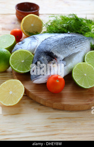 Le poisson frais sur la carte avec les citrons et limes, de l'alimentation Banque D'Images