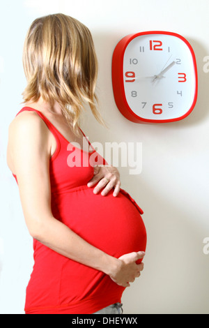 Femme enceinte réveil regardant dans la cuisine Banque D'Images