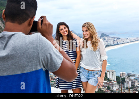 Young man photographing young women, Casa Alto Vidigal, Rio de Janeiro, Brésil