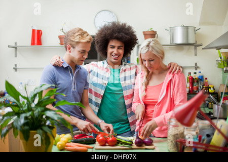 Les amis de préparer des légumes en cuisine Banque D'Images