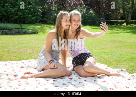Deux adolescentes on picnic blanket taking self portrait