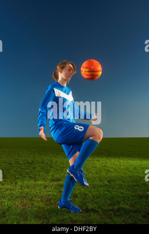 Footballeur femelle keepy uppy with ball Banque D'Images