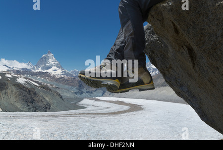 Homme assis sur le roc par le Matterhorn, Zermatt, Canton du Valais, Suisse Banque D'Images