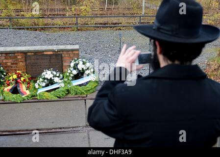 Berlin, Allemagne. 05Th Nov, 2013. Un homme prend une photo de la couronnes qui étaient prévues à l'Gleis 17 (lit. la voie 17) memorial au cours d'une cérémonie à l'occasion du 75e anniversaire du Pogrom nuit à Berlin, Allemagne, 08 novembre 2013. Photo : BRITTA PEDERSEN/dpa/Alamy Live News Banque D'Images