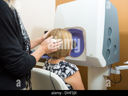 Réglage de l'opticien tête du patient pour l'examen de la rétine Banque D'Images