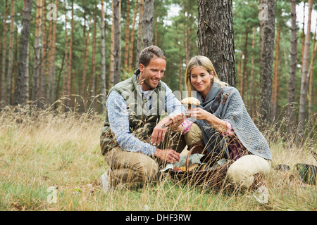 Couple à la recherche de champignons en forêt Banque D'Images