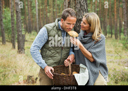 Couple à la recherche de champignons en forêt Banque D'Images