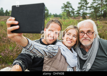 Woman holding digital tablet taking photograph Banque D'Images