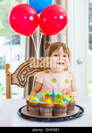 Fille assise en face de Cake at Home Banque D'Images