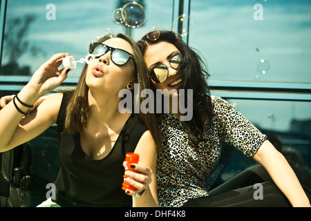 Deux jeunes woman blowing bubbles Banque D'Images