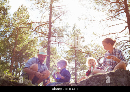 Family having picnic assis sur des rochers Banque D'Images