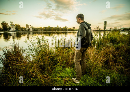 Jeune homme debout sur l'herbe à la recherche de l'eau, Russie Banque D'Images