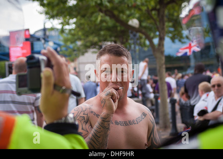 Un membre de l'EDL est monté sur un cordon de police, fixant les officiers de police et des passants. Banque D'Images