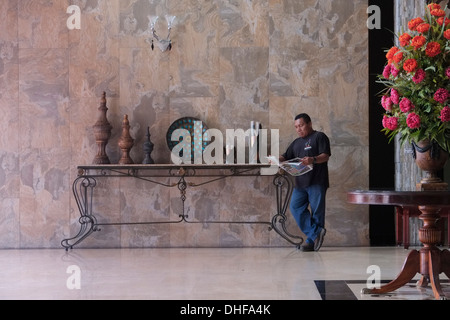 Un homme Guna lit un journal dans le hall de l'hôtel Gran Azuero, dans la province de Chiter Herrera, République du Panama Banque D'Images