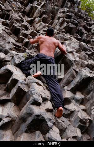 Un homme monte pieds nus à Los Ladrillos un mur de basalte de roche causé par l'activité volcanique dans la province de Boquete République du Panama Banque D'Images