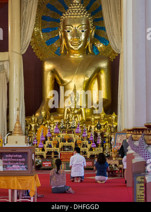 Les dévots bouddhistes priant dans le temple principal du Wat Phra Singh de Chiang Mai, Thaïlande. Banque D'Images