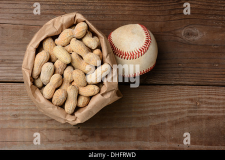 Un sac d'arachides et un base-ball sur un vieux banc en bois au stade de baseball. Format horizontal avec l'exemplaire de l'espace. Banque D'Images