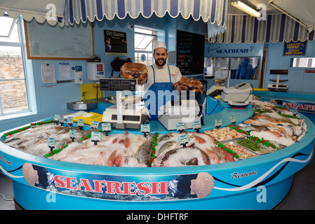 Poissonnier tenant deux tourteaux comestibles à l'appareil photo. Seafresh pêches, St Peter Port, Guernsy, Channel Islands Banque D'Images