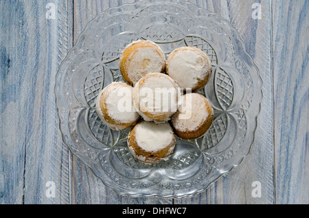 Brioches à la cannelle dans un vieux bac en verre sur une table en bois Banque D'Images