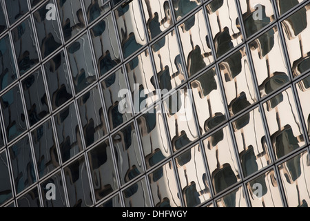 Un gratte-ciel en réflexion déformée par les fenêtres d'un bâtiment voisin à la Defense, Paris, France, Europe. Banque D'Images