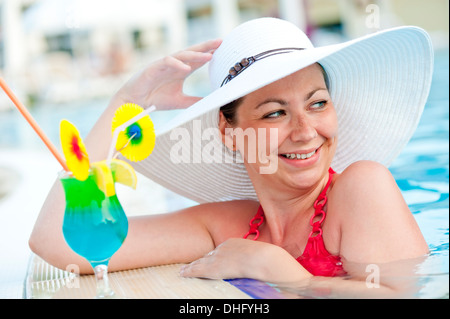 Belle femme dans un chapeau et cocktail Banque D'Images