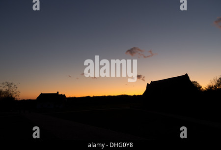Silhouette de cottage et grange à Wat Tyler Country Park au coucher du soleil Banque D'Images