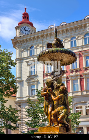 Image d'orientation verticale fontaine sculpturale sur petite place de la ville en face de l'immeuble typique de Prague, en République tchèque. Banque D'Images