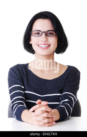 Le portrait de jolie femme assise à une table. Isolé sur blanc. Banque D'Images